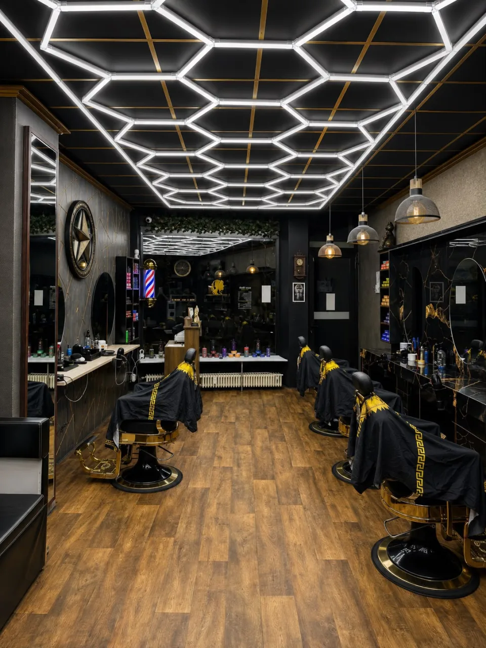 Blick durch den Salon mit goldenen Barberstühlen, Holzboden und der Hexagon-LED-Decke