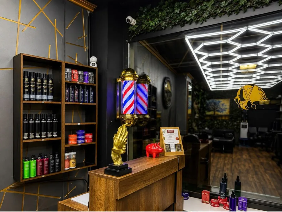 Regal mit Pflegeprodukten neben der goldenen Barber-Säule am Empfang